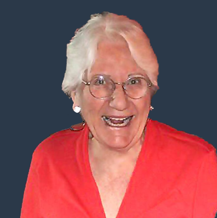 Carol Rabun - a woman with short grey hair, clear-rimmed glasses and a red shirt smiling as if laughing.